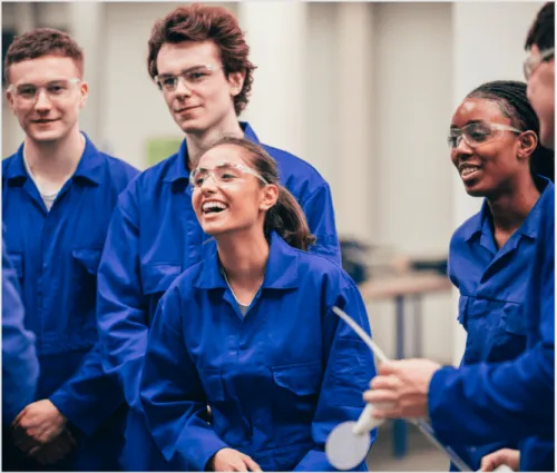 Group of people wearing safety glasses and blue boiler suits